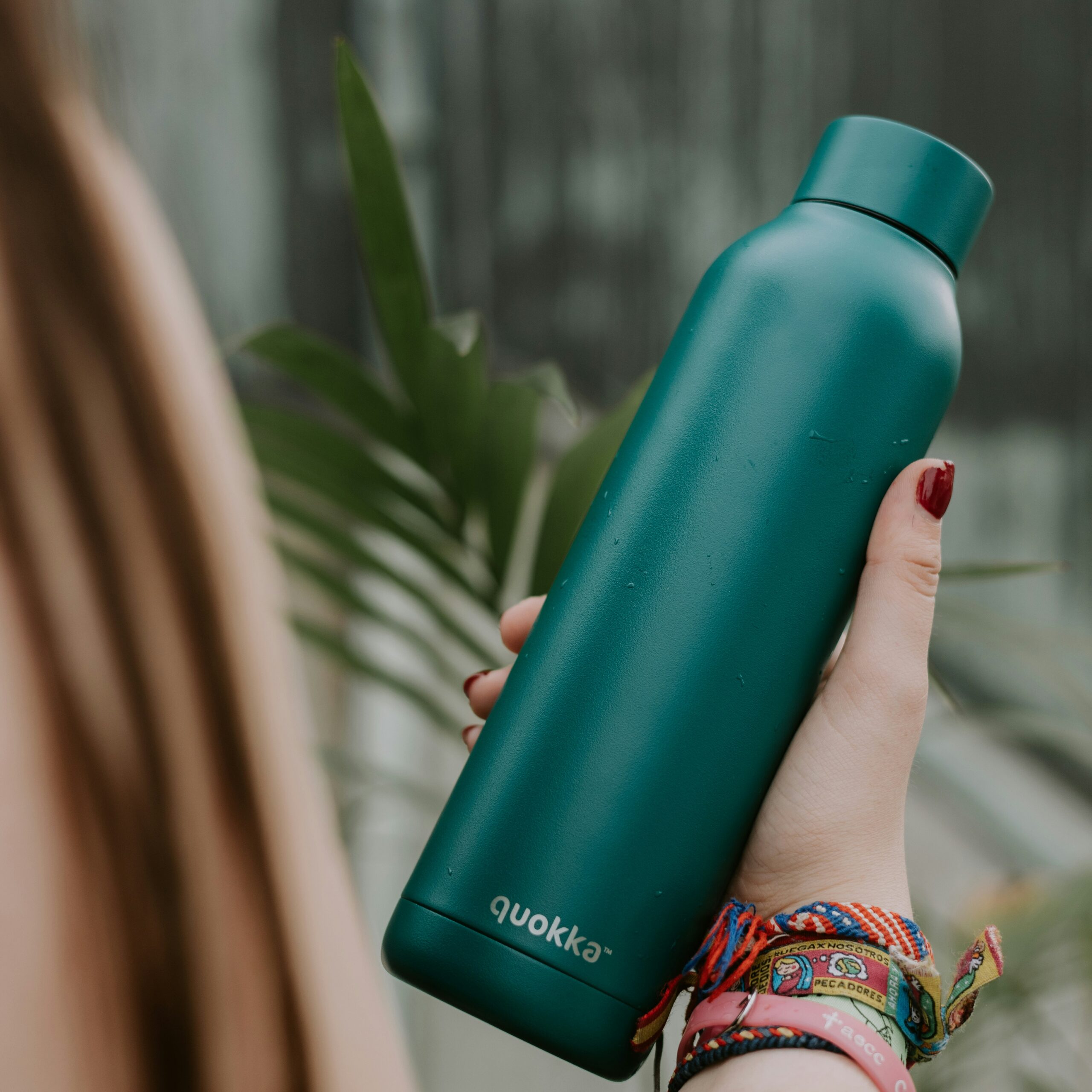 a woman holding a green water bottle in her hand